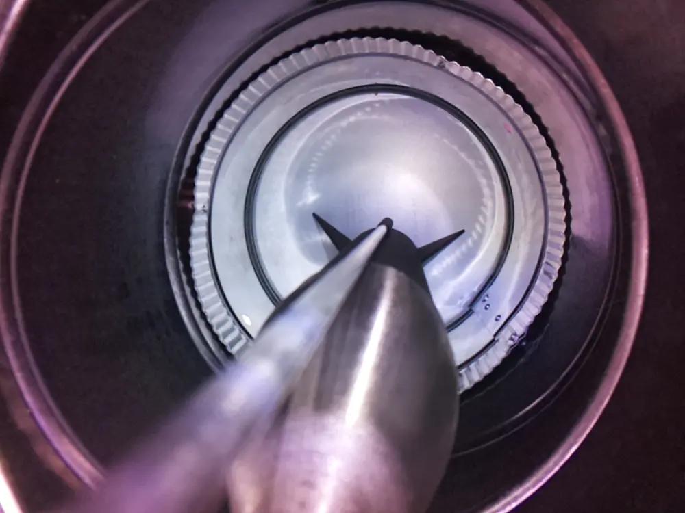 An above-view photo of a 3D-printed model rocket on an Estes Porta-pad E launch pad enclosed in a steel silo made of air vent ducting. The rocket cone is translucent gray, and the rest is matte black.